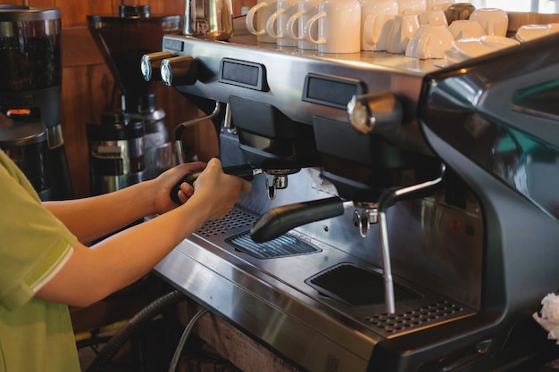 Barista bereidt zich voor om koffie te zetten met een koffiezetapparaat.