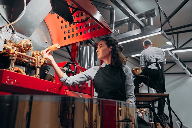 Barista controleert de koffiebonen in de fabrieksmachine Onderaanzicht