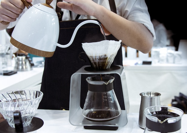 Barista die koffie, barista gietende druppelkoffie giet in glas