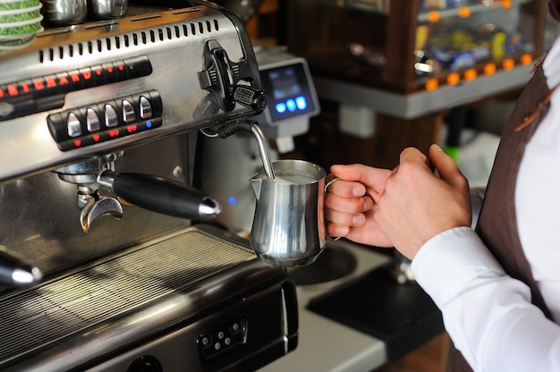 Barista die koffie maakt. Melk klaarmaken voor cappuccino