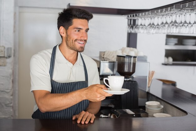 Barista die kop van koffie houdt bij het cafÃ ©