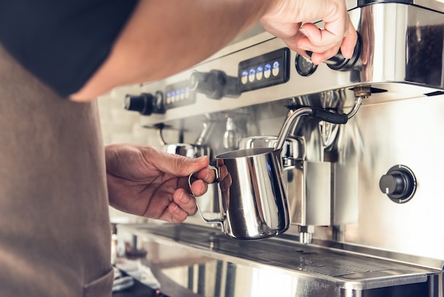 Barista die melk met koffiemachine stomen