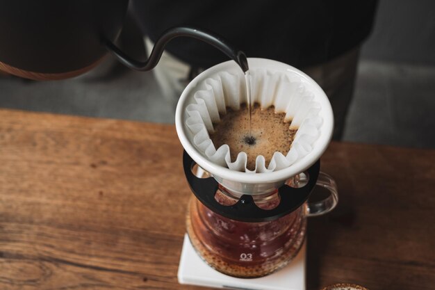 写真 バリスタが滴するコーヒーとスローコーヒー 木製のバースタイル