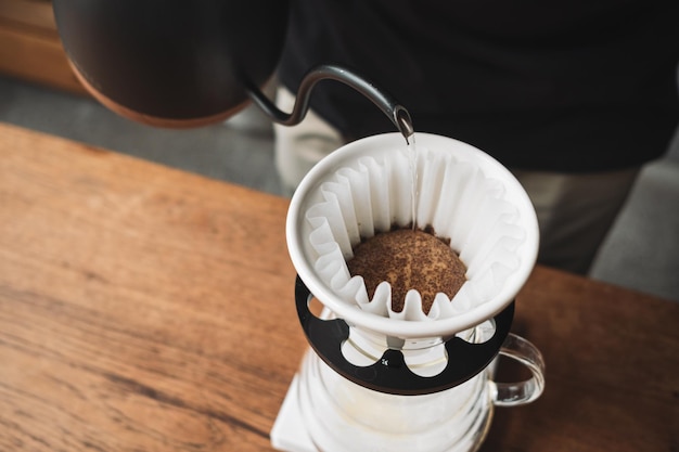 Photo barista dripping coffee and slow coffee wooden bar style