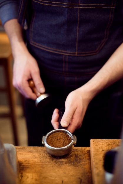 Barista drukt gemalen koffie met sabotage in een koffiebar