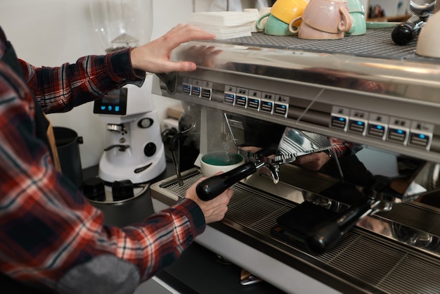 Barista gebruikt een koffiezetapparaat om koffie te zetten in café