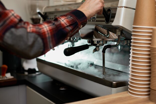 Barista gebruikt een koffiezetapparaat om koffie te zetten in café