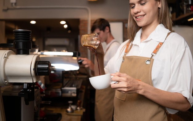 Barista giet koffie in een kop in een koffiewinkel close-up