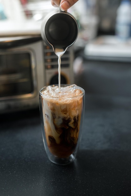 Barista gieten koffie in glas