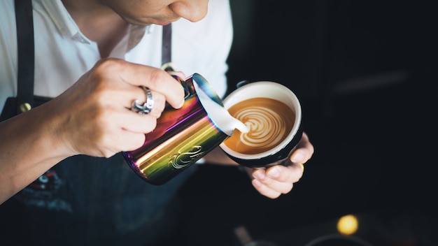 Foto barista gieten melk naar koffie espresso latte kunst in café