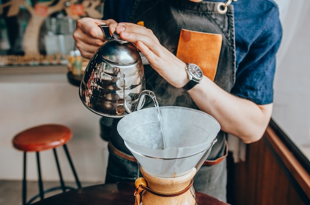 Barista gietend kokend water uit ketel