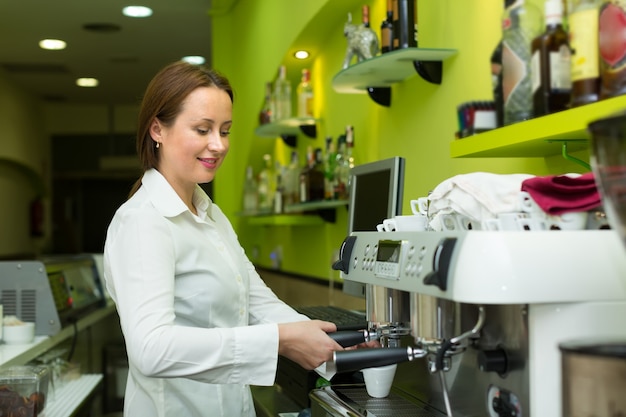 Barista girl making coffee in cafe