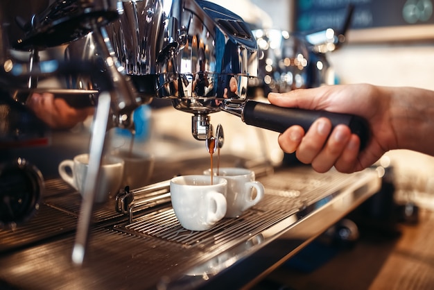 Photo barista hand pours beverage from coffee machine