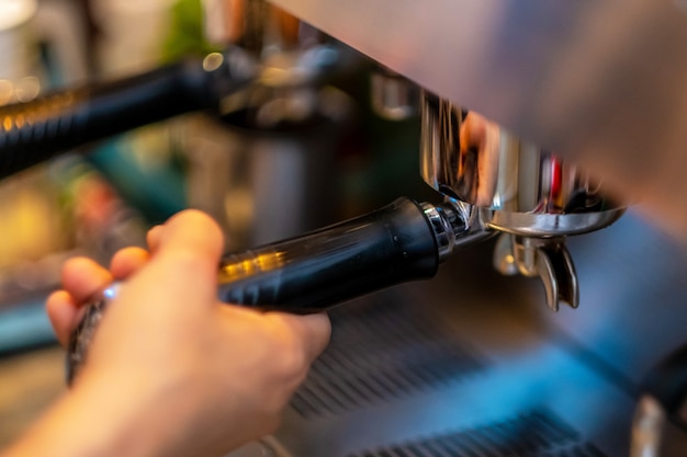 Barista-handen die koffie van de machine maken.