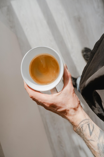 Photo barista holding a cup of espresso in his hand