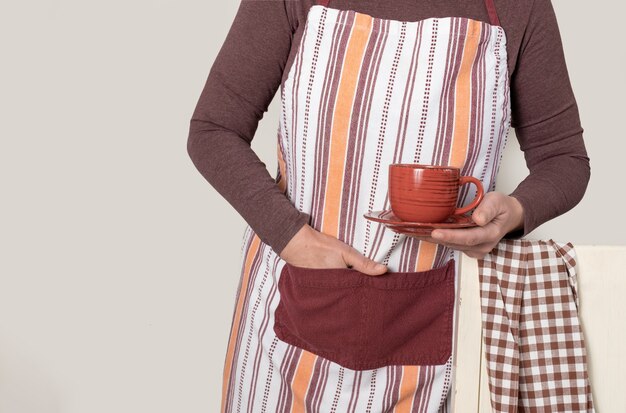 Barista holding red cup of coffee or tea on the white background