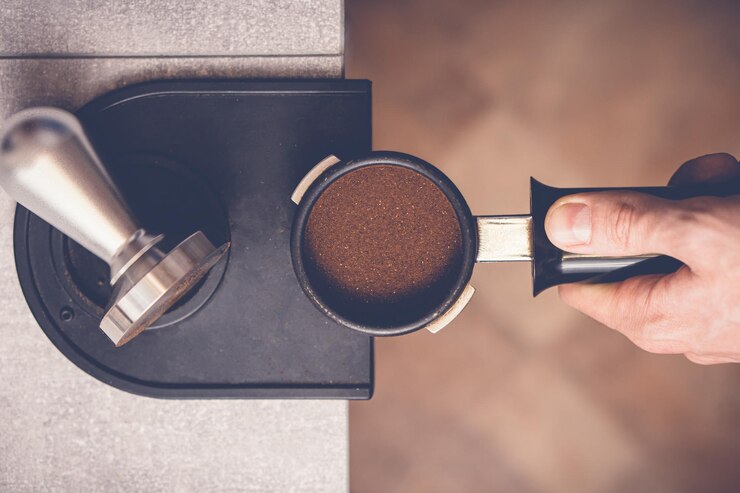 Barista knoeit met koffie in portafilter met behulp van sabotage Closeup verse koffie bereidingsproces