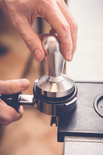 Barista knoeit met koffie in portafilter met behulp van sabotage Closeup verse koffie bereidingsproces