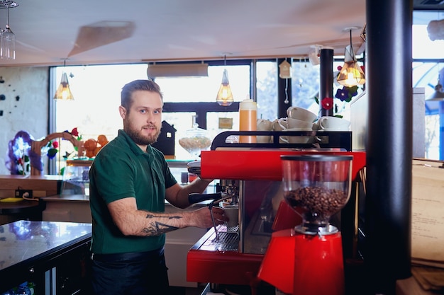 Barista maakt een warme drank op de koffiemachine aan de bar