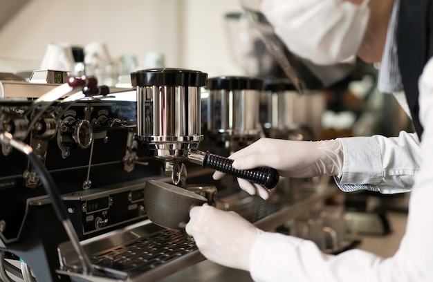 Barista maakt hete koffie, werknemer die koffie maakt door moderne koffiemachine