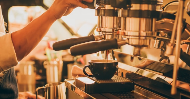 barista make coffee latte art with coffee espresso machine in coffee shop cafe in vintage 