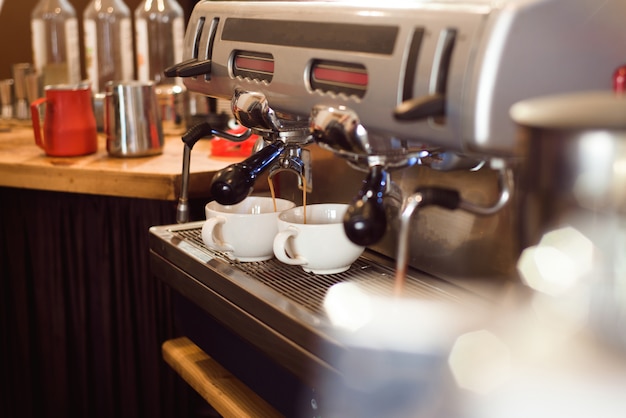 바리 스타는 카페에서 에스프레소 머신으로 커피 라떼 아트를 만듭니다.