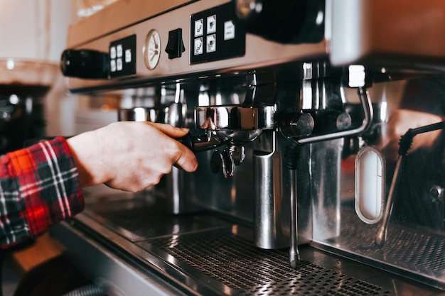 Barista makes aromatic coffee.