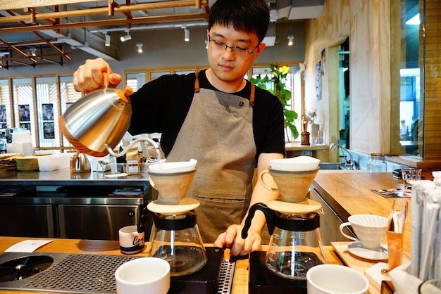 カフェでコーヒーを作っているバースタ