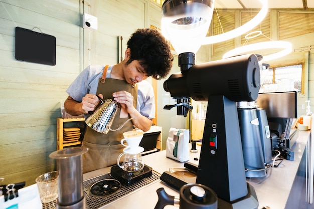 Barista making pour-over coffee with alternative method called Dripping. 