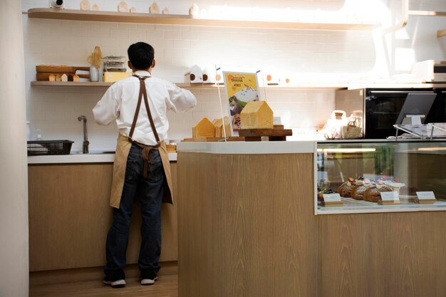 Barista mannen personeel en servicemedewerker man aan het werk in klassiek modern café koffie en bakkerij restaurant voor Thaise klant mensen eten drankjes en gebruiken service in Pathum Thani, Thailand