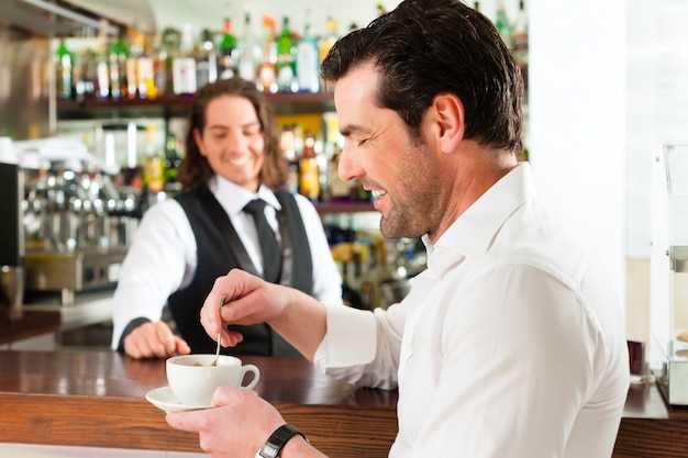 Barista met cliënt in zijn café of coffeeshop