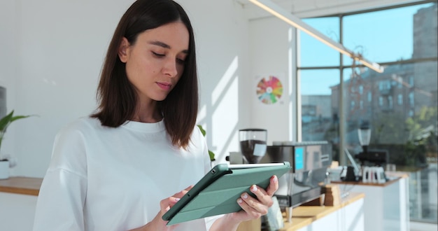 Barista met digitale tablet in café Het vrouwelijke personeel controleert de producten in de winkel met tablets Coffeeshopconcept