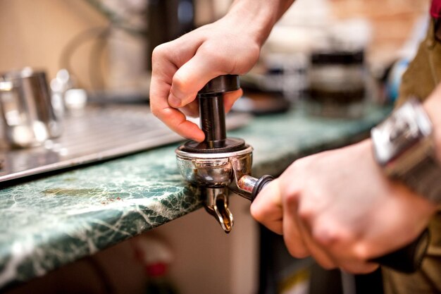 Barista met sabotage en zuigerportafilter die espress maakt