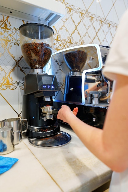 Foto barista che gestisce una macchina per l'espresso in un caffè affollato durante la fretta mattutina