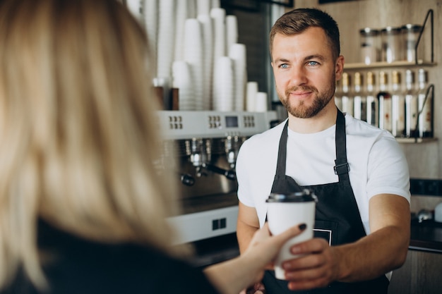 Barista overlevende klant met koffie in een coffeeshop