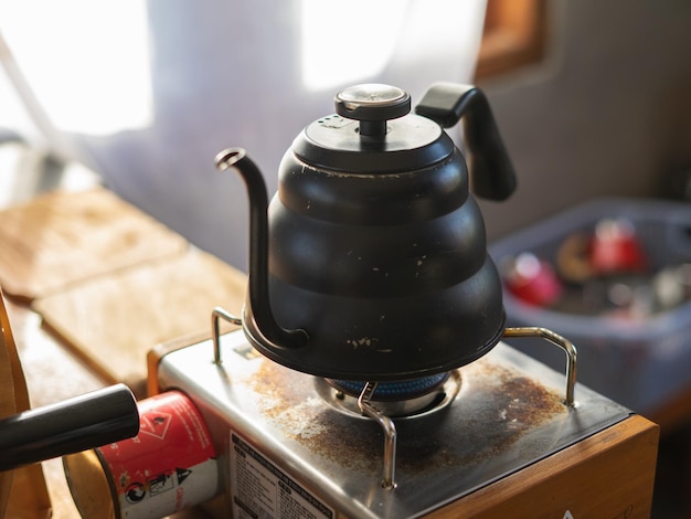 Barista pouring coffee from mocha pot coffee maker to a coffee cup Hand holding Italian classic mocha pot pouring coffee