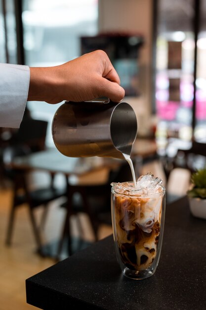 Barista pouring coffee in glass