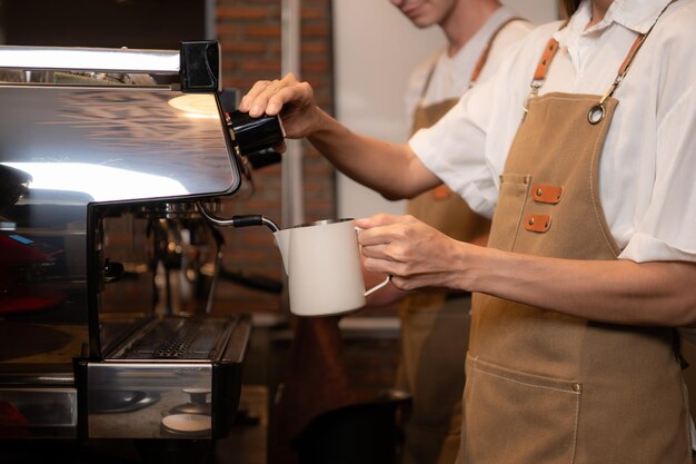 コーヒーショップのクローズアップでカップにコーヒーを注ぐバースタ