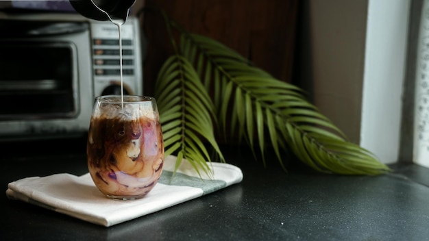 Barista pouring milk in glass