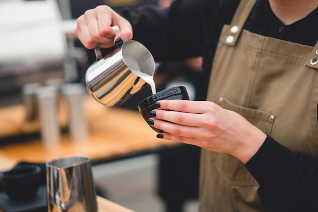 Barista pours milk into a cup