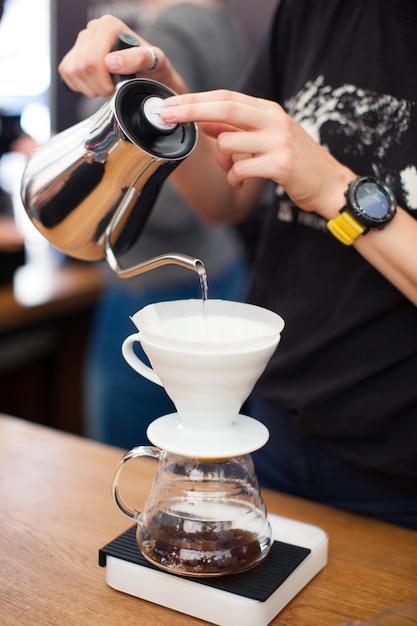 Foto il barista versa l'acqua dal bollitore