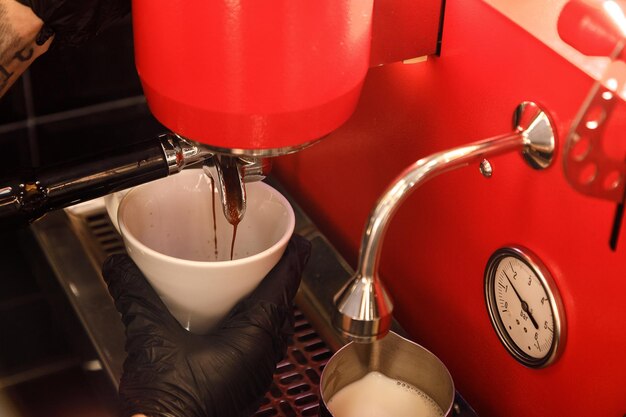 Barista prepares coffee at the coffee machine in the cafe