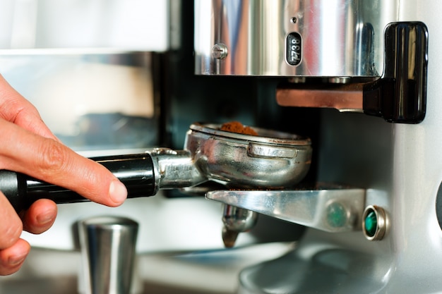 Barista prepares espresso in his coffee shop