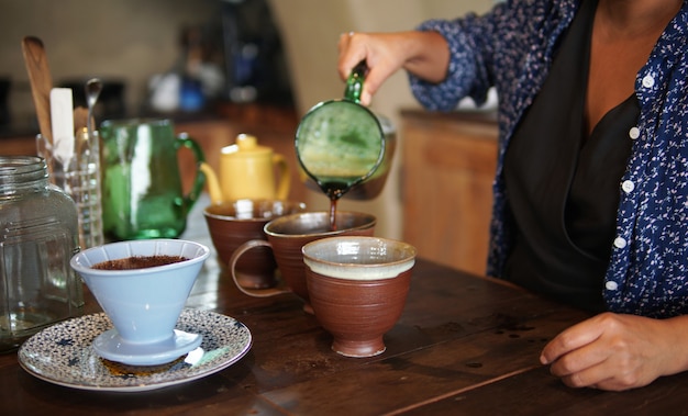 Photo barista preparing brewing coffee with coffee maker and drip kettle. dripping ground coffee with filter