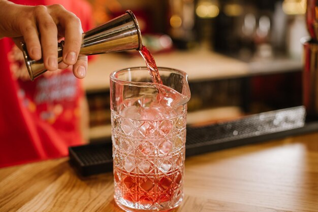 A barista preparing a cocktail on the bar table