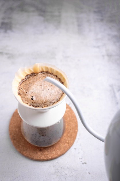 Il barista stava versando acqua calda sul caffè macinato.