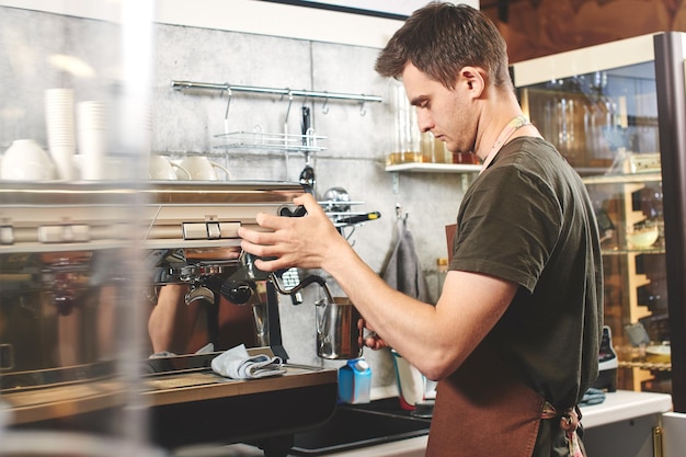 Barista at work. Guy makes coffee