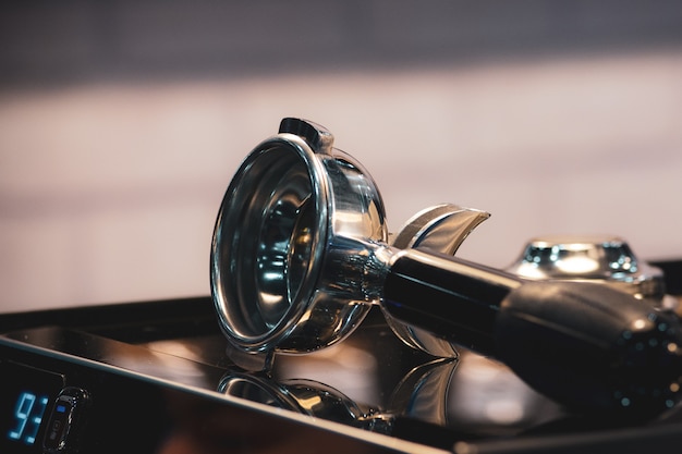 Barista che lavora in un coffee shop, primo piano del barista preme caffè macinato con tamper