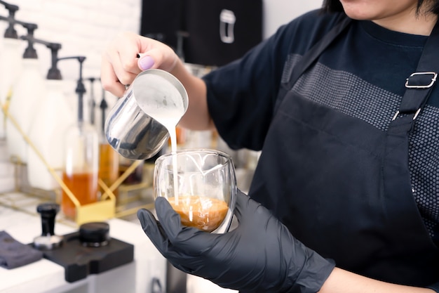 Barista zet een koffie met koffiezetapparaat in café