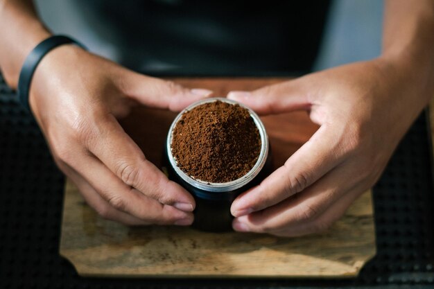 バリスタはカップ ポットで熱いコーヒー豆を準備して蒸気用のコーヒーを作ります